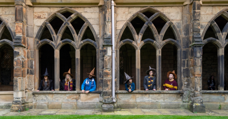 Group of young people dressed as wizards and witches at Durham Cathedral Cloisters.